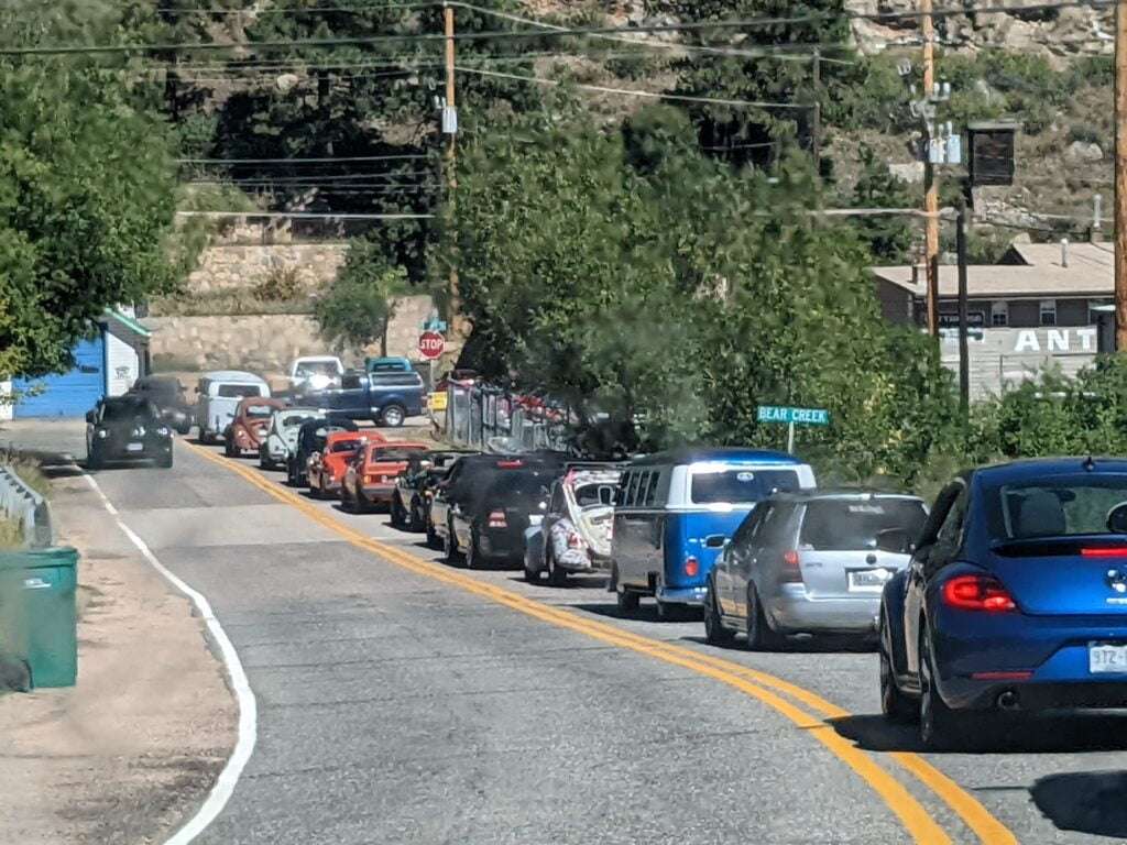 line of VW vehicles on berm of 2 way road